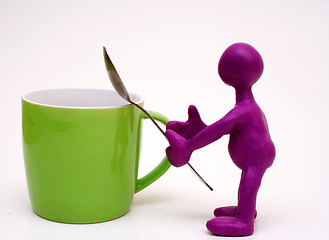 Image showing Purple puppet of plasticine holding melhior spoon