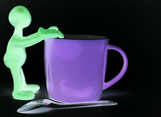 Image showing Shaded puppet of plasticine rest on cup