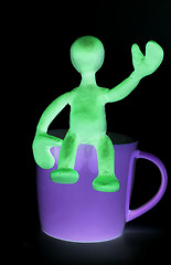 Image showing Shaded puppet of plasticine sitting on cup