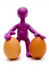 Image showing Purple puppet of plasticine holding two eggs