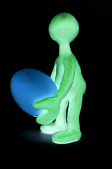 Image showing Shaded puppet of plasticine holding one egg