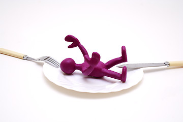 Image showing Purple puppet of plasticine laying between threat