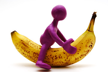 Image showing Purple puppet of plasticine riding on banana