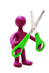 Image showing Purple puppet of plasticine holding green scissors