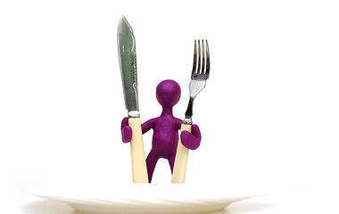 Image showing Purple puppet of plasticine standing behind plate