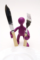 Image showing Purple puppet of plasticine standing behind plate