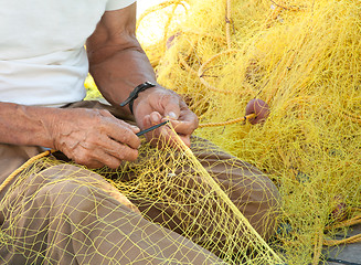 Image showing Fisherman Mending His Fishing Net in Greece