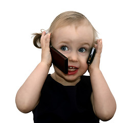 Image showing funny little girl talking on the two phones, isolated on white