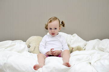 Image showing little girl sitting on a bed