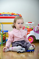 Image showing little girl in a room with toys, playing with cars