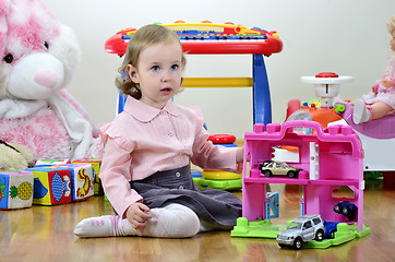 Image showing little girl in a room with toys, playing with cars