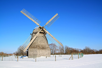 Image showing aging wind mill on winter field 