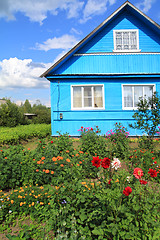 Image showing flowerses near rural wooden building