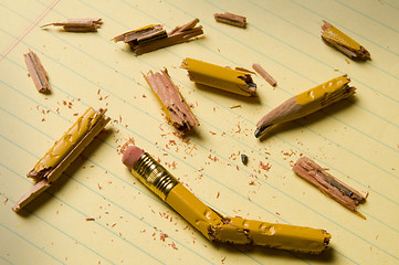 Image showing Broken pencil fragments on yellow paper