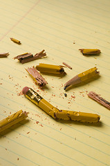 Image showing Broken pencil fragments on yellow paper