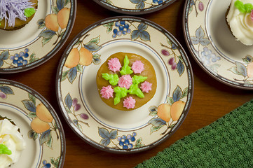 Image showing Ornately decorated cupcakes on dishes