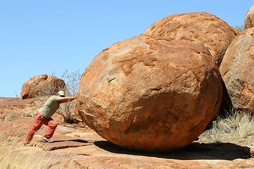 Image showing man pushing devil marbles