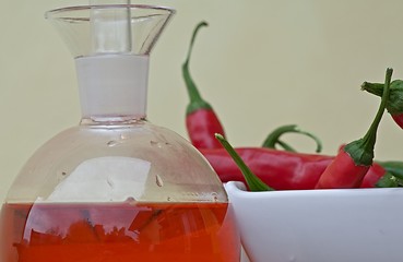 Image showing Chilli peppers and spicy oil