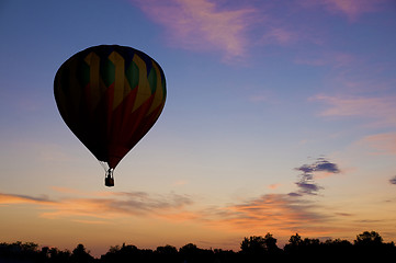 Image showing Hot-air balloon floating against a reddish dawn sky