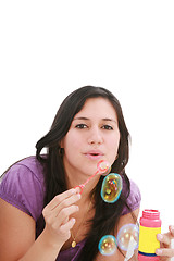 Image showing Young woman portrait making soap bubbles. 