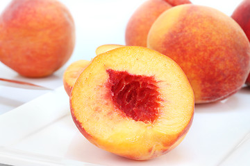 Image showing Open peach macro on white plate with selective focus on center.