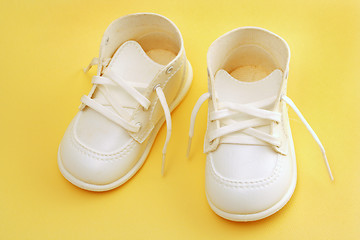 Image showing baby shoes over yellow