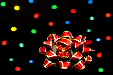 Image showing Red and Gold Bow in front of bokeh lights.