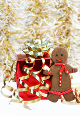 Image showing Gingerbread man cookie with a red scarf standing next to Christm