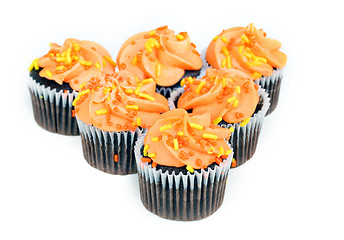 Image showing Chocolate cupcakes with orange icing on white with copy space.