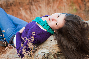 Image showing Shot of a young woman lying on log 