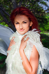 Image showing beautiful woman in white against blue sky and green trees