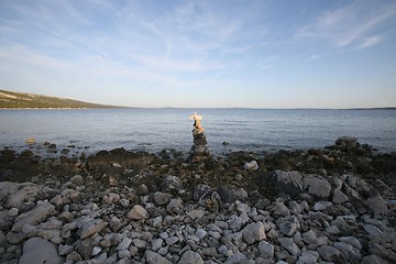 Image showing Cross, rocks stacked one one top of another on beach