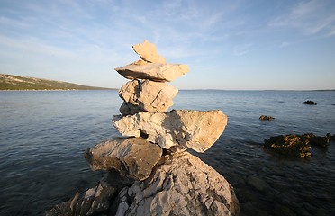 Image showing Cross, rocks stacked one one top of another on beach