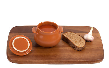 Image showing Borsch with bread and garlic on wooden kitchen board