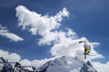 Image showing Freestyle ski jumper with crossed skis