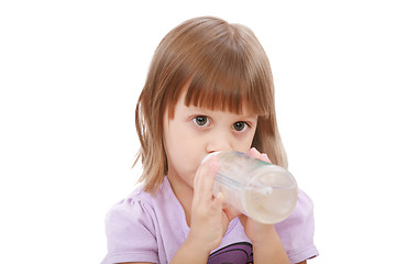 Image showing Little girl drinking water of her bottle. White background 