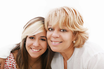 Image showing mother and attractive young daughter smiling happily, looking at