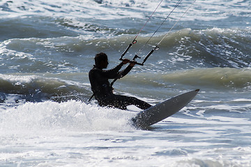 Image showing Silhouette of kite surfer jumping over the waves