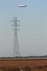 Image showing Blimp floating above the marshland and a pylon