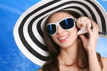 Image showing woman listens seashell