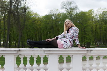 Image showing blonde girl sitting on the railing 