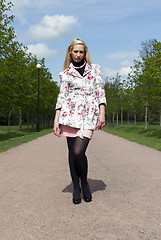 Image showing blonde girl standing in an alley in the park