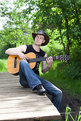 Image showing man playing guitar in the woods