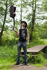 Image showing man holding a guitar on his finger 