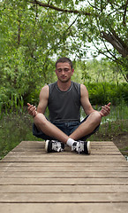 Image showing man sitting in the lotus position and meditates