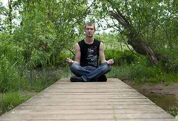 Image showing man sitting in the lotus position and meditates