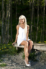 Image showing girl sitting on a bench in the woods