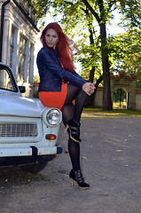 Image showing redheaded girl near the old car