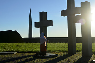 Image showing Girl praying at the Crosses at sunset