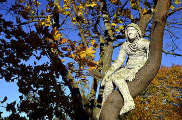 Image showing man of plaster sitting on a tree